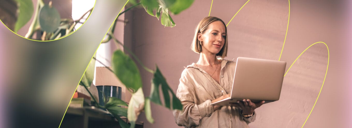 Women with pastel pink background looking at laptop - branded