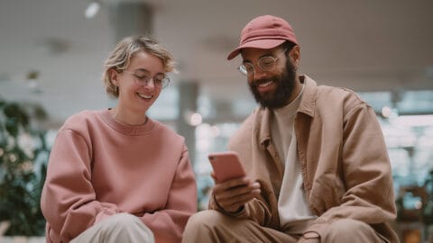 Two people online shopping on a phone