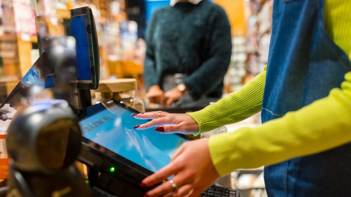 Saleswoman using POS - checkout prompt to join loyalty program